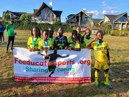 Feeducate FC players holding the Sharing is Caring banner